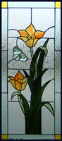 Butterfly bevel with orange tulips made up this stained glass panel, light and dark green with gluechip textured background.